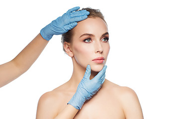 Image showing surgeon or beautician hands touching woman face