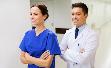 Image showing smiling doctor in white coat and nurse at hospital