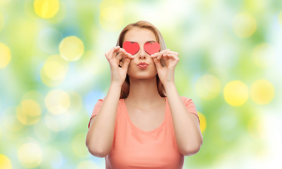 Image showing happy young woman with red heart shapes on eyes