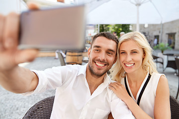 Image showing couple taking selfie with smatphone at restaurant