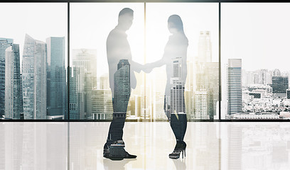 Image showing business partners silhouettes making handshake