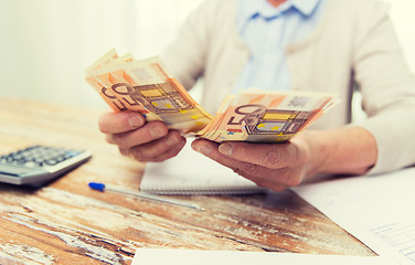 Image showing close up of senior woman counting money at home