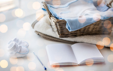 Image showing close up of baby clothes for newborn and notebook