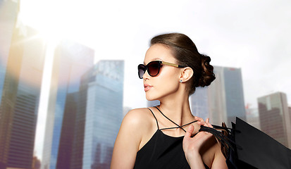 Image showing happy woman in black sunglasses with shopping bags