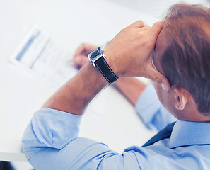 Image showing stressed man filling tax form