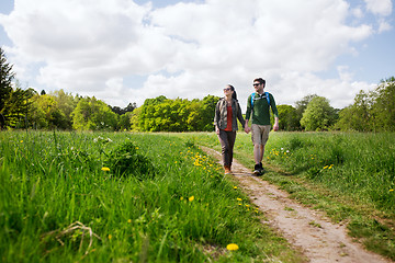 Image showing happy couple with backpacks hiking outdoors