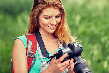 Image showing happy woman with backpack and camera outdoors