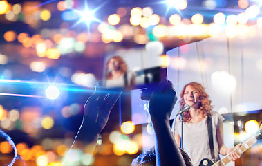 Image showing hands with tablet pc taking video of music concert