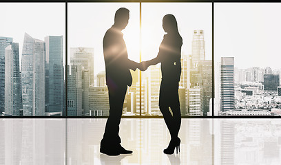 Image showing business partners silhouettes making handshake