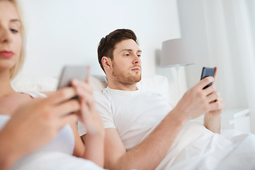 Image showing couple with smartphones in bed