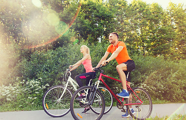 Image showing happy couple riding bicycle outdoors