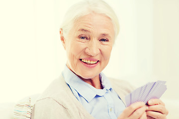 Image showing happy senior woman playing cards at home