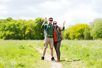 Image showing happy couple with backpacks hiking outdoors