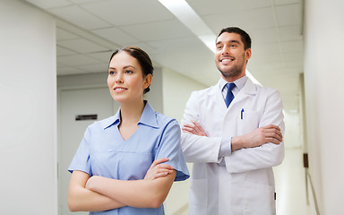 Image showing smiling doctor in white coat and nurse at hospital