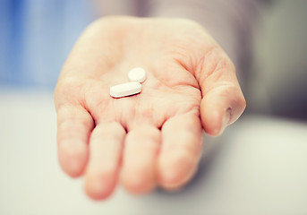 Image showing close up of senior woman hand with pills