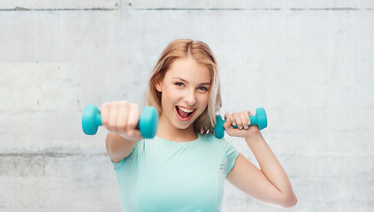 Image showing smiling beautiful young sporty woman with dumbbell