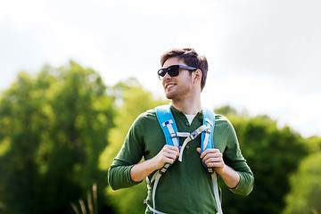 Image showing happy young man with backpack hiking outdoors