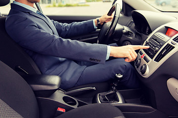 Image showing close up of young man in suit driving car