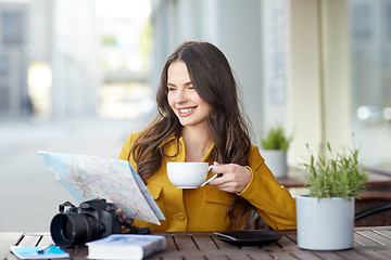 Image showing happy woman with map drinking cocoa at city cafe