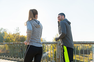 Image showing happy couple with earphones running outdoors