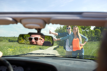 Image showing couple hitchhiking and stopping car on countryside