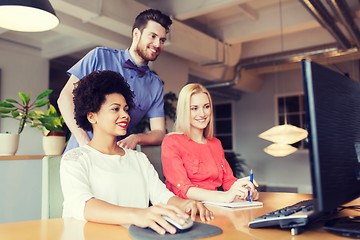 Image showing happy creative team with computer in office