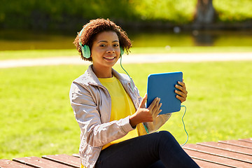 Image showing happy african woman with tablet pc and headphones