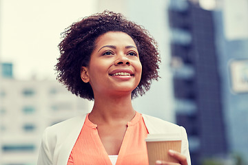 Image showing happy african businesswoman with coffee in city