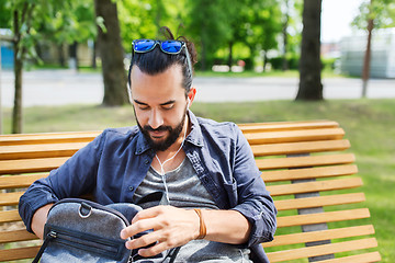 Image showing man with backpack and earphones in city