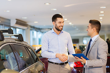 Image showing happy man shaking hands in auto show or salon