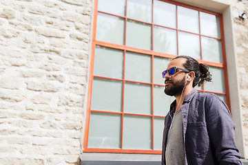 Image showing man with earphones listening to music in city