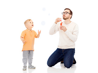 Image showing father with son blowing bubbles and having fun