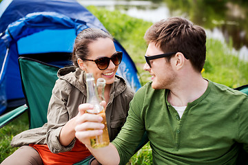 Image showing happy couple clinking drinks at campsite tent