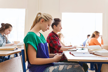 Image showing student girl with smartphone texting at school