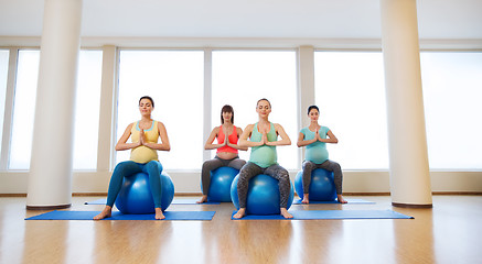 Image showing happy pregnant women exercising on fitball in gym