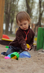 Image showing Little beauty girl playing at sand-box