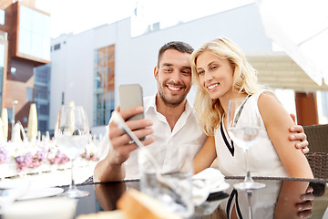 Image showing couple taking selfie with smatphone at restaurant