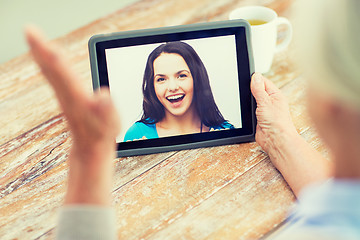 Image showing senior woman with photo on tablet pc at home