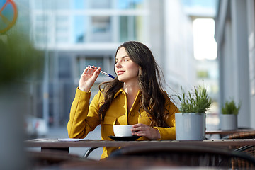 Image showing happy woman with notebook drinking cocoa at cafe