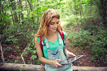 Image showing happy woman with backpack and tablet pc in woods
