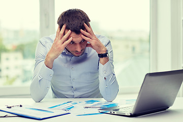 Image showing stressed businessman with laptop at office