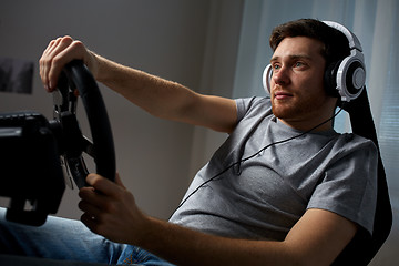 Image showing man playing car racing video game at home