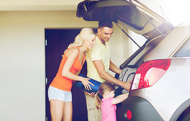 Image showing happy family packing things to car at home parking