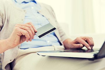 Image showing senior woman with laptop and credit card at home