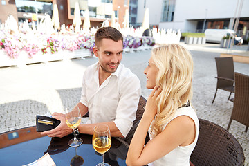 Image showing happy couple with wallet paying bill at restaurant