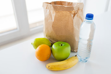 Image showing basket of fresh ripe fruits and water at kitchen