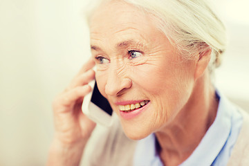 Image showing senior woman with smartphone calling at home