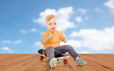 Image showing happy little boy on skateboard showing thumbs up