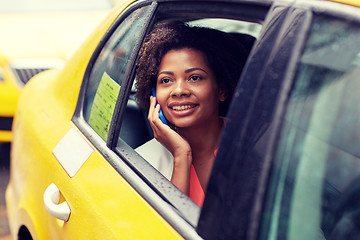 Image showing happy african woman calling on smartphone in taxi