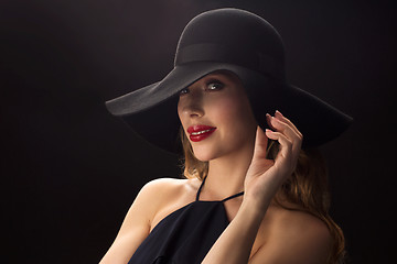 Image showing beautiful woman in black hat over dark background